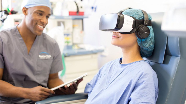 Patient in gown sitting with a VR headset on.
