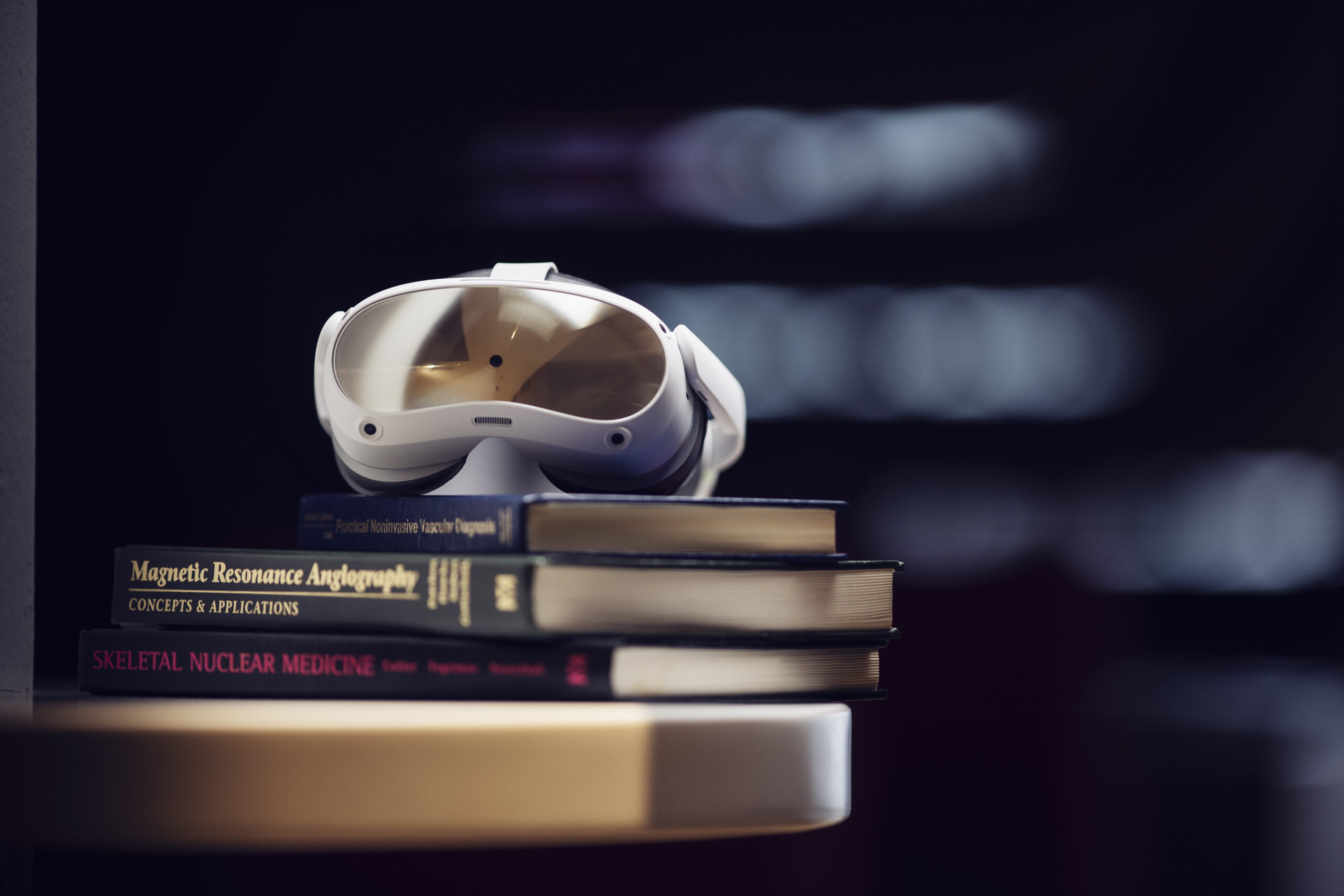 Virtual reality headset sitting on top of medical and radiology textbooks.